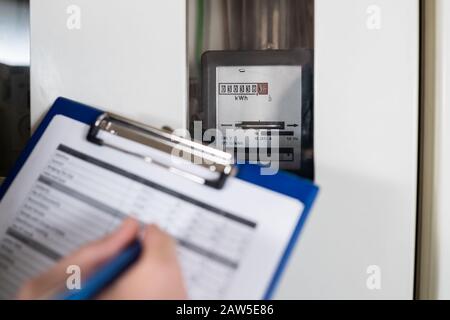 Close-up Of A Technician Hand Writing Reading Of Meter On Clipboard Stock Photo
