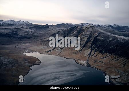 Drone view of landscape of canyon with mountains and lake against cloudy sky Stock Photo