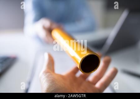 Close-up Of A Hand Passing Golden Relay Baton To Businessman Stock Photo
