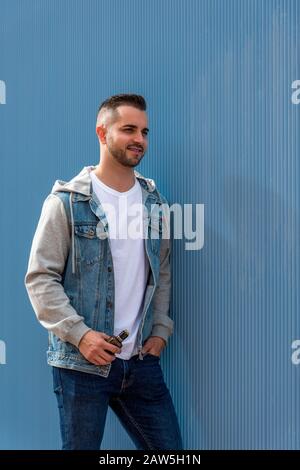 Young man with an electronic cigarette over blue background Stock Photo