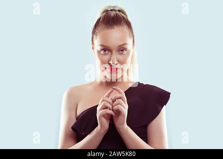 Plot. Closeup portrait of sneaky, sly, scheming young woman plotting something isolated on light blue background. Negative human emotions, facial expr Stock Photo