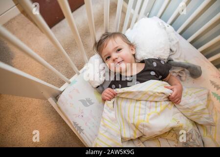 High angle view of toddler girl laying in her bed. Stock Photo