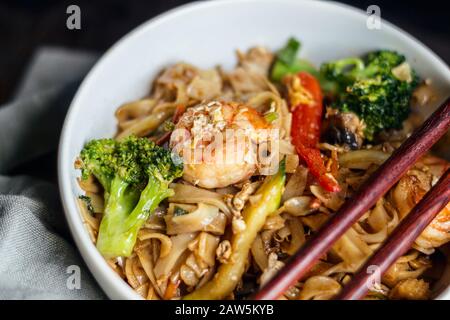 Seafood thai noodles with shrimps, broccoli, zucchini, pepper and soy sauce Stock Photo