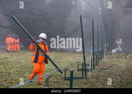 Denham, UK. 6 February, 2020. An environmental activist observes engineers working on behalf of HS2 constructing a security fence at Denham Ford. Works planned for the HS2 high-speed rail link in the immediate vicinity include the construction of a Bailey bridge across the ford and a compound in Denham Country Park requiring the felling of ancient trees. Some of the site lies within a wetland nature reserve forming part of a Site of Metropolitan Importance for Nature Conservation (SMI). Credit: Mark Kerrison/Ģ����ý Live News Stock Photo