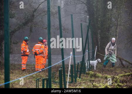 Denham, UK. 6 February, 2020. An environmental activist observes engineers working on behalf of HS2 constructing a security fence at Denham Ford. Works planned for the HS2 high-speed rail link in the immediate vicinity include the construction of a Bailey bridge across the ford and a compound in Denham Country Park requiring the felling of ancient trees. Some of the site lies within a wetland nature reserve forming part of a Site of Metropolitan Importance for Nature Conservation (SMI). Credit: Mark Kerrison/Ģ����ý Live News Stock Photo