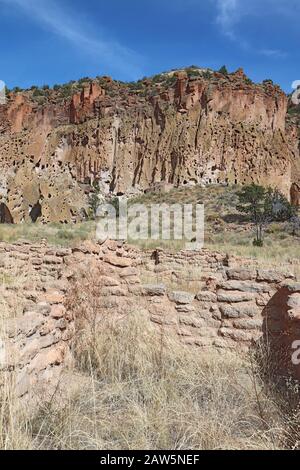 Part of the Tyuonyi ruins of the ancestral Pueblo peoples with a reconstructed pueblo by the cliffs along the main loop trail in Frijoles Canyon at Ba Stock Photo