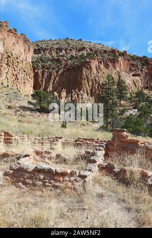 Part of the Tyuonyi ruins of the ancestral Pueblo peoples with a reconstructed pueblo by the cliffs along the main loop trail in Frijoles Canyon at Ba Stock Photo