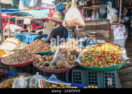 Bangkok, Thailand - January 9th 2020: Food stall selling bugs, tomatoes and mushrooms on Khlong Toei wet market. This is the largest wet market in the Stock Photo