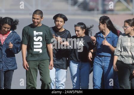 Hispanic junior high students hang out together outside of school during lunch hour. Stock Photo