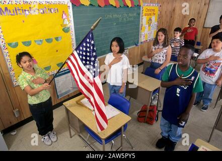 Elementary school children recite The Pledge of Allegiance to the ...