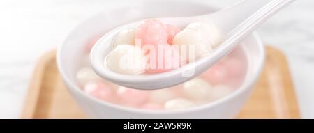 Tang yuan, tangyuan, delicious red and white rice dumpling balls in a small bowl. Asian traditional festive food for Chinese Winter Solstice Festival, Stock Photo