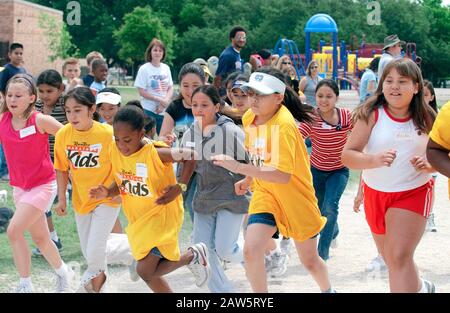 Fourth grade girls at the starting line of the one-mile run during their elementary school's spring track and field day in Austin, TX. Stock Photo