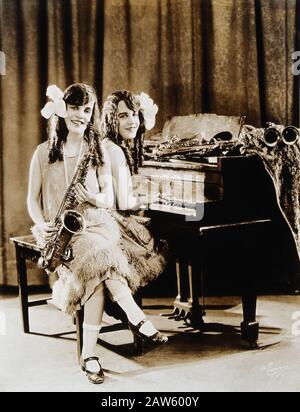 1927  ca , NEW YORK , USA : The  British-born conjoined twins sisters Daisy and Violet Hilton ( 1908 - 1969 ), with piano and saxophones . Photo by Pr Stock Photo
