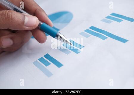 closeup of man hand analyzing bar chart on paper  Stock Photo