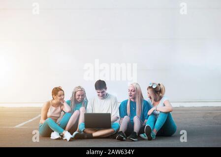 Group of young people looking at notebook computer outside Stock Photo