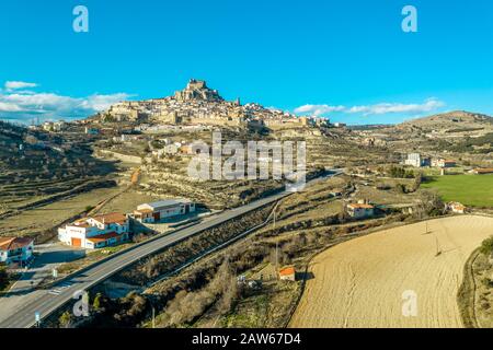 Aerial sunset view of Morella, medieval walled town with semi circular towers and gate houses crowed by a fortress on the rock in Spain Stock Photo