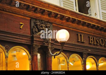 Original cast fitting ball and bracket lamp in detail, arched window tops, shop 7 -  Galerie Véro-Dodat, 75001 Paris, France Stock Photo