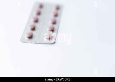 Medicines and pills. Multicolored medicines on a white background close-up. Plate with pink pills on a white background. Multi-colored tablets that Stock Photo