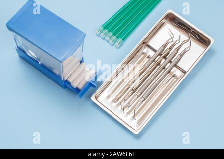 Set of composite filling instruments for dental treatment, saliva ejectors and cotton sponges. Medical tools in stainless steel tray. Stock Photo