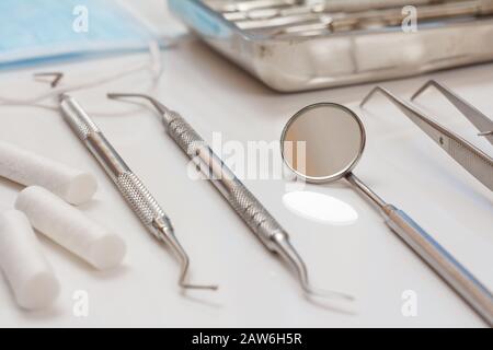 Set of composite filling instruments for dental treatment. Medical tools and protective mask. Close-up view. Shallow depth of field. Stock Photo