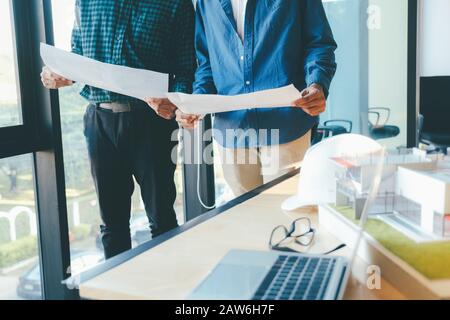 Image of engineer meeting for architectural project working with partner and engineering tools on workplace. Stock Photo