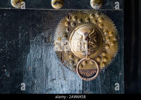 Shenzhen,China,April,2019. Copper door buckle with a lion on it. The Gankeng Hakka town creates cultural tourism, pastoral leisure, ecological vacatio Stock Photo