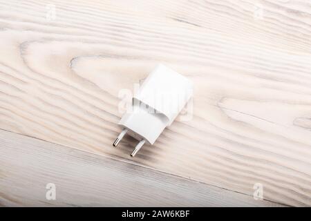 Smartphone battery charger on wooden desk. switching power adaptor, charging power supply for phone. Stock Photo
