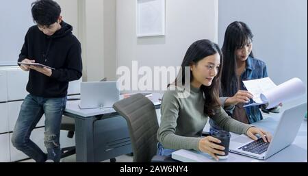 Group Students Smile and have fun and using tablet It also helps to share ideas in the work and project. And also review the book before the exam Stock Photo