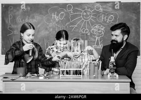 school kids scientist studying science. back to school. happy children teacher. Little kids learning chemistry in school laboratory. students doing science experiments with microscope in lab. Stock Photo