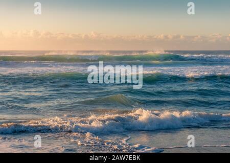Ocean seascape with beautiful sunlit waves at sunrise. Summer beach vacation surf background Stock Photo
