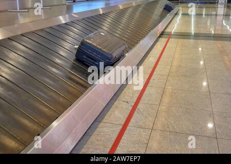 Lost suitcase on treadmill of the airport baggage carousel. Stock Photo