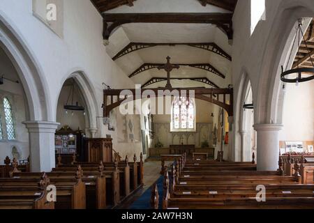 Looking east down the nave towards the altar and east window with historic wooden  pews, roof beams, whitewashed walls with columns, interior of villa Stock Photo