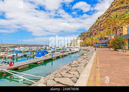 Promenade of the town Calheta in the west of Madeira. On the left the new marina of the town. Stock Photo