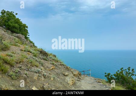 A tourist route along a trail in the mountains of the southern coast of Crimea, a beautiful view of the Black Sea and rocks. Golitsyna trail, Republic Stock Photo