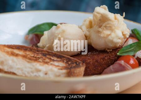 Close up of breakfast meal of poached eggs on sourdough toast with cherry tomatoes and greens. Food background Stock Photo