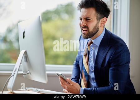Man sat at computer thoughtful Stock Photo