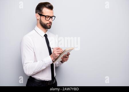 Photo of handsome young business man preparing corporate speech writing creative idea focused wear specs white office shirt black pants tie isolated Stock Photo