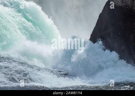 The roaring waters of the Rhine Falls between the rocks from above. Stock Photo