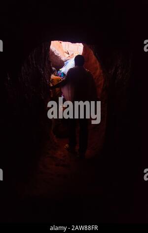 Lalibela, Ethiopia - Nov 2018: People passing in the tunnel of hell connecting underground churches in Lalibela Stock Photo