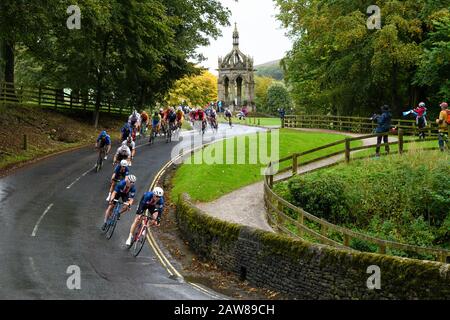 Pack (peloton) of junior male road racing cyclists, riding bikes on country lane, competing in cycle race - UCI World Championships, Bolton Abbey, UK. Stock Photo