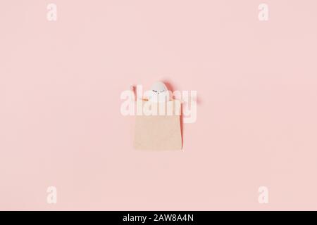Happy Easter. White egg with painted eyes in the rag bag. Flat lay, top view, copy space. Stock Photo