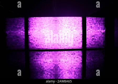 a transparent plastic partiontion consist of many block shape hit by purple light in behind Stock Photo