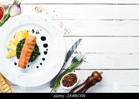 Baked salmon fillet with spinach and apple on a plate. Top view. Free copy space. Stock Photo