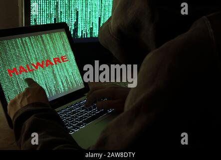 Hacker or person working on computers malware Stock Photo