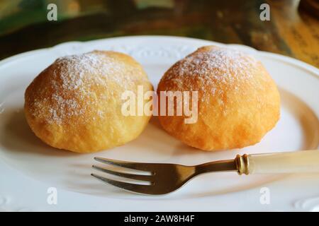 Pair of tasty fresh fried Georgian doughnuts sprinkled with icing sugar Stock Photo