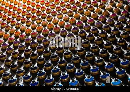 Rows of color paint spray cans placed on a black wall. Abstract colour palette Stock Photo