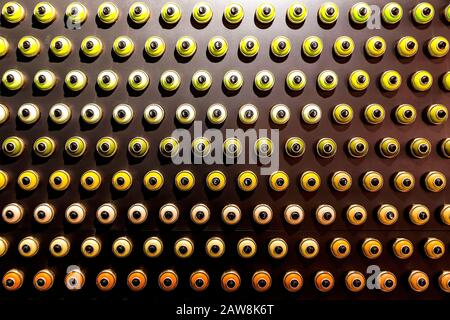 Rows of color paint spray cans placed on a black wall. Abstract colour palette Stock Photo