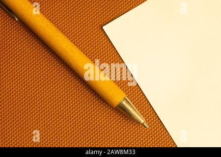 White paper with wooden pen on a brown background. copy space Stock Photo