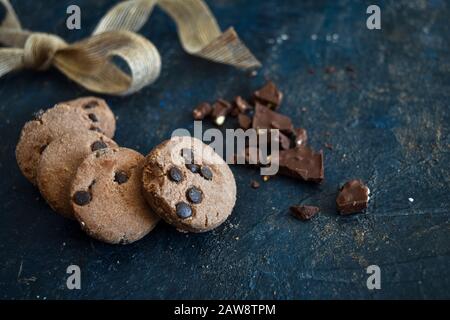 Fresh homemade Chocolate chip cookies with ribbon and dark chocolate, gluten free, cafe, bakery, top view on a dark rustic background, copy space. Stock Photo