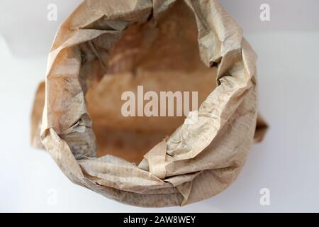 Empty paper bag on a white background top view. Paper bag for bakery products. Crumpled brown paper bag. Stock Photo